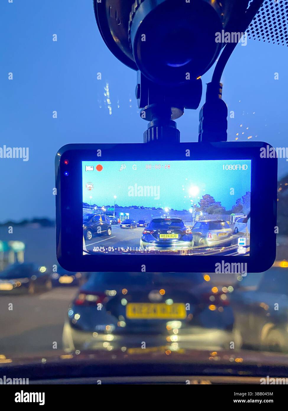 A dashcam mounted in the window of a car records video which may be used as evidence in the event of an incident occurring while driving. - Smartphone Captured Stock Image