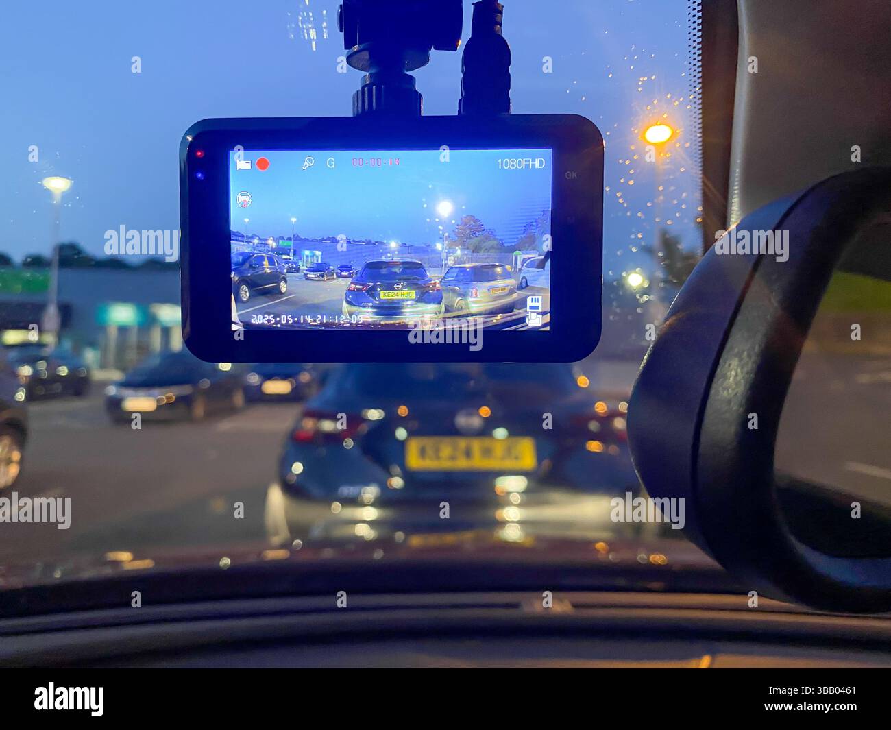 A dashcam mounted in the window of a car records video which may be used as evidence in the event of an incident occurring while driving. - Smartphone Captured Stock Image