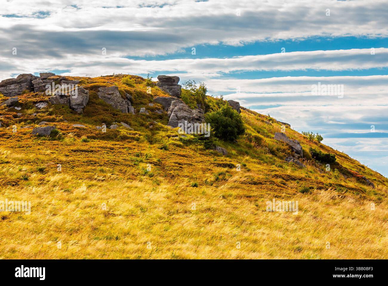 beautiful mountain landscape in late summer. scenic view of rock formation among orange grass. dramatic sky with grey clouds. end of vacation season i Stock Photo