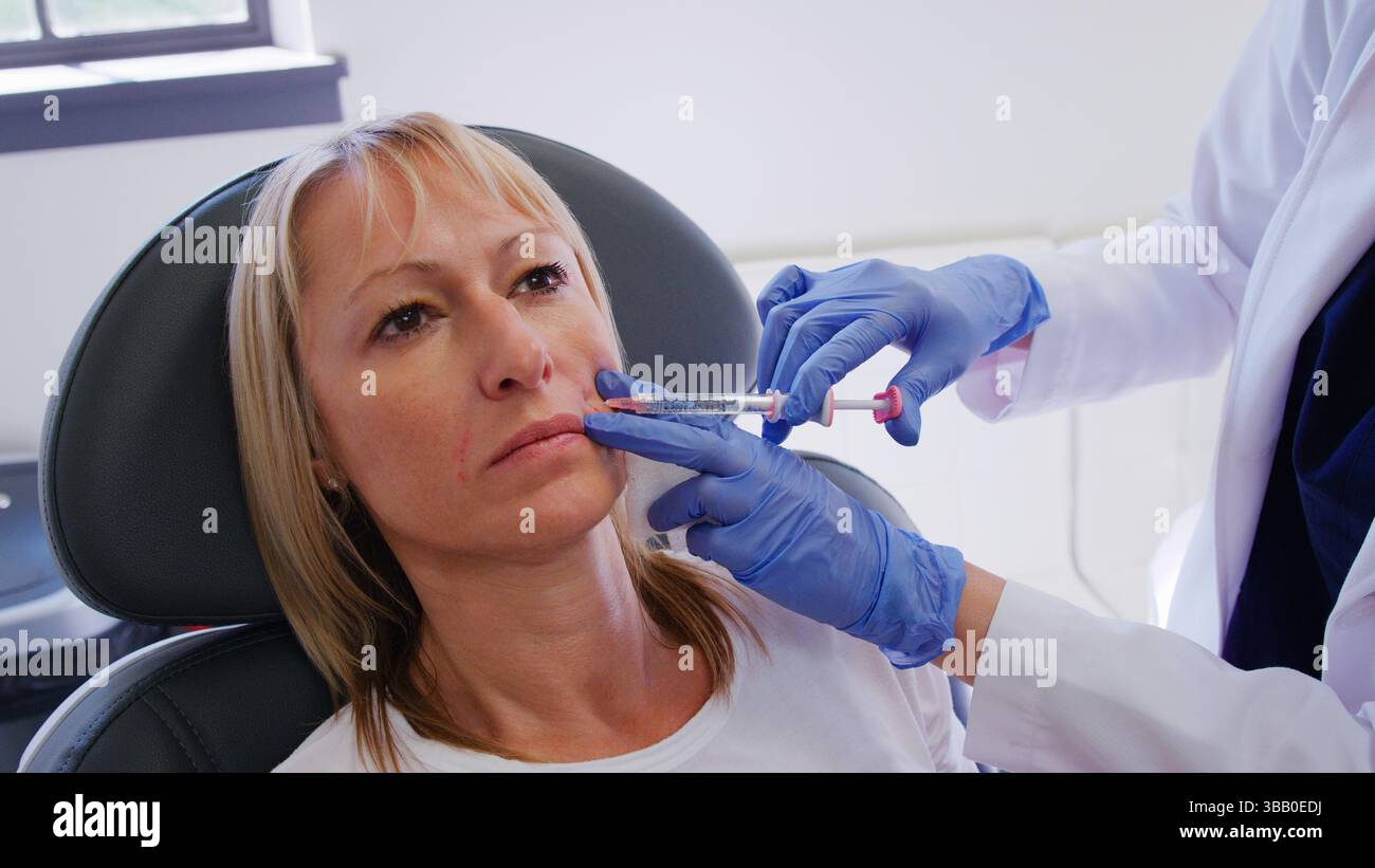 Mature Woman Sitting In Chair Being Give Botox Injection By Female ...