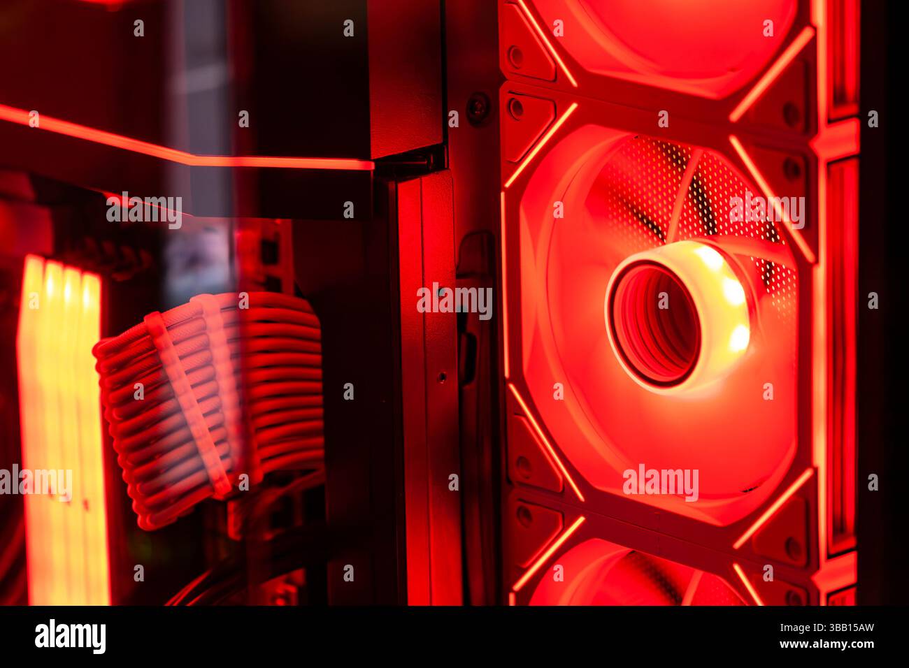 Red illuminated cooling fan actively dissipating heat in a custom-built personal computer, showcasing advanced technology and gaming aesthetics Stock Photo