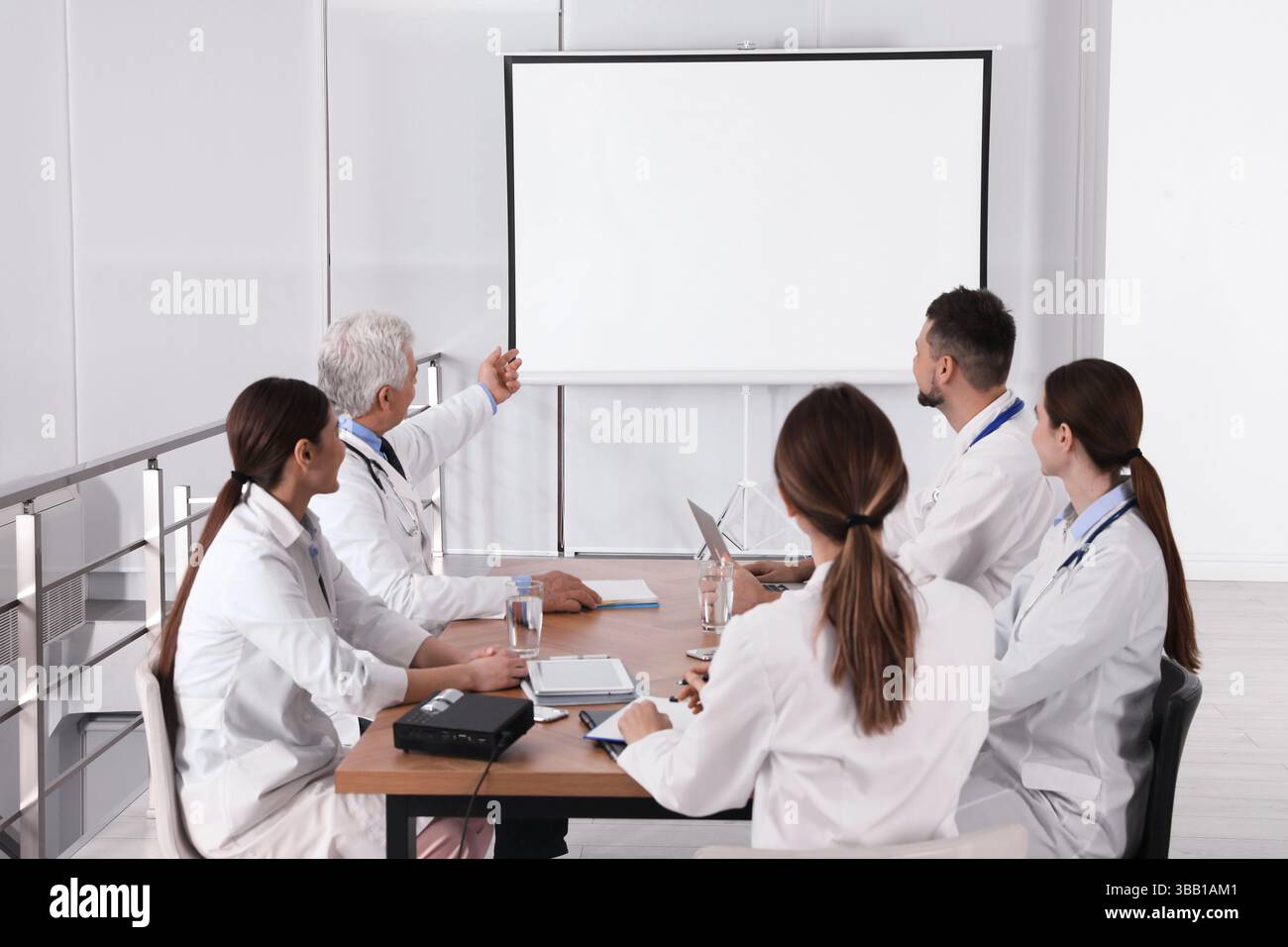 Team of doctors using video projector during conference indoors Stock Photo