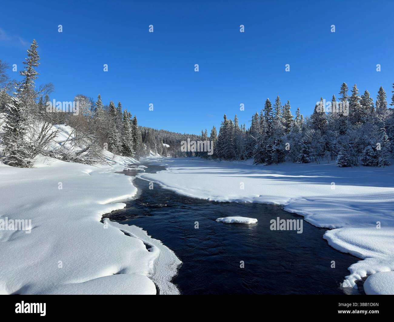 Winter scene showcases a river flowing through a snowy landscape under a clear sky in north Sweden. - Smartphone Captured Stock Image