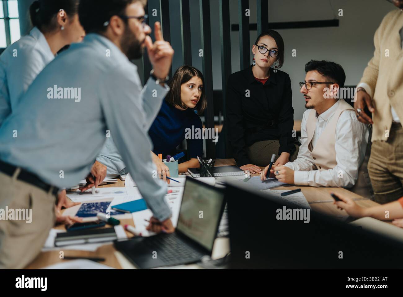 Diverse team brainstorming ideas around a conference table Stock Photo ...