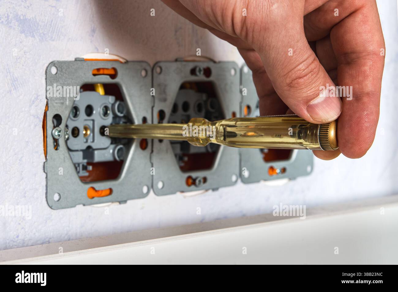 Socket Inspection Using a voltage tester screwdriver to check for live phase in a wall ...