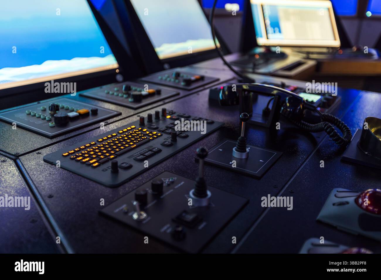 Marine navigation simulator. A modern control room featuring illuminated consoles, joysticks, communication devices, and digital screens, illustrating Stock Photo
