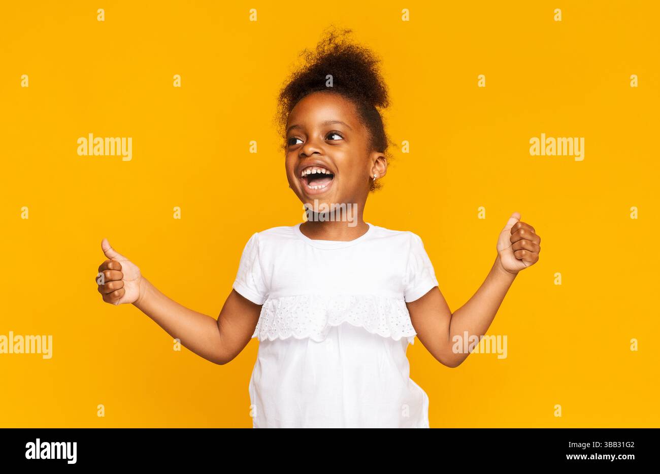 Emotional african little girl showing thumbs up and shouting Stock ...