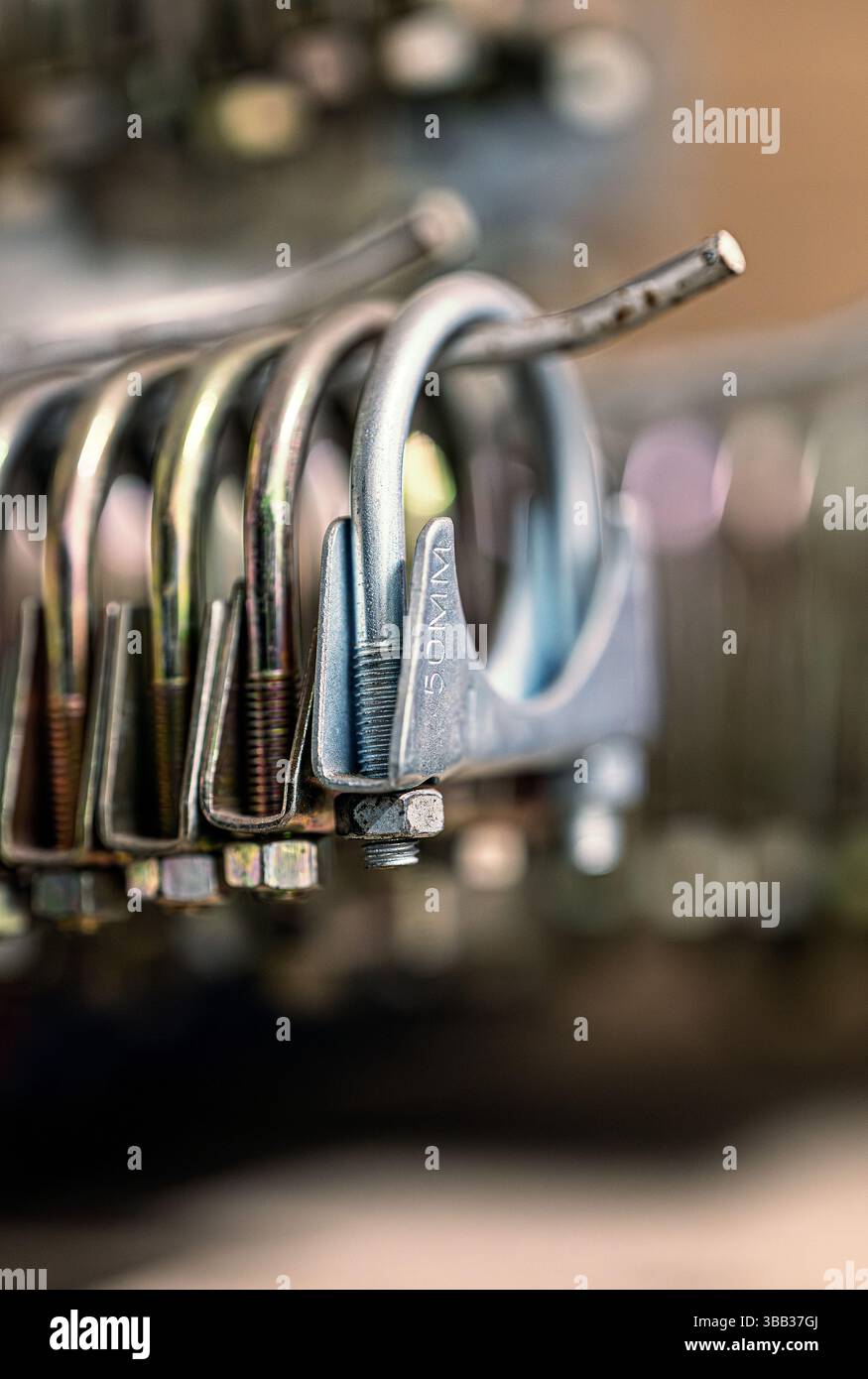 A collection of 50mm exhaust clamps hanging on rack in a tyre and exhaust depot. Norfolk, UK Stock Photo