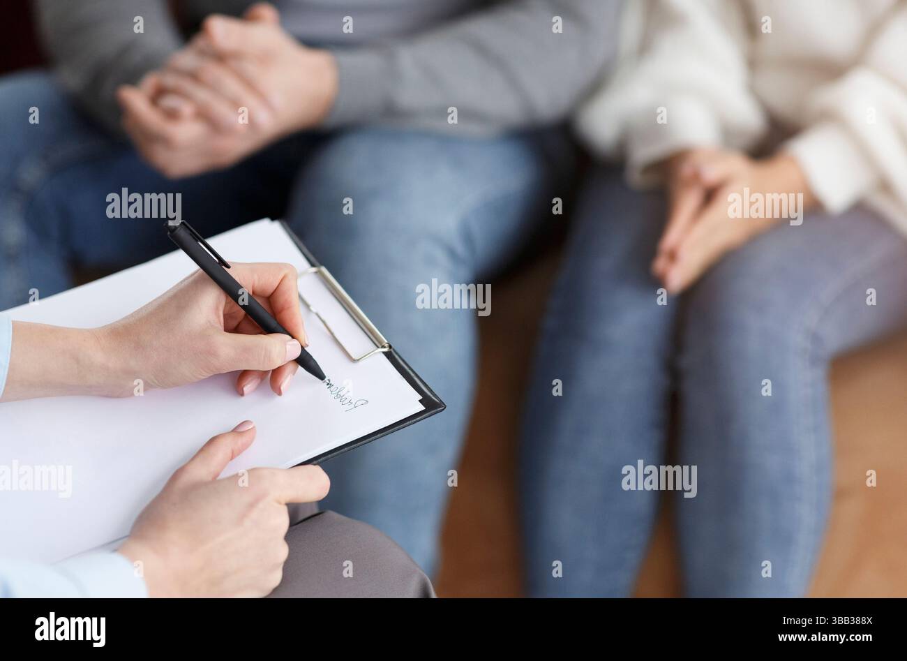 Marriage Consultant Taking Notes Talking With Couple In Office, Cropped Stock Photo