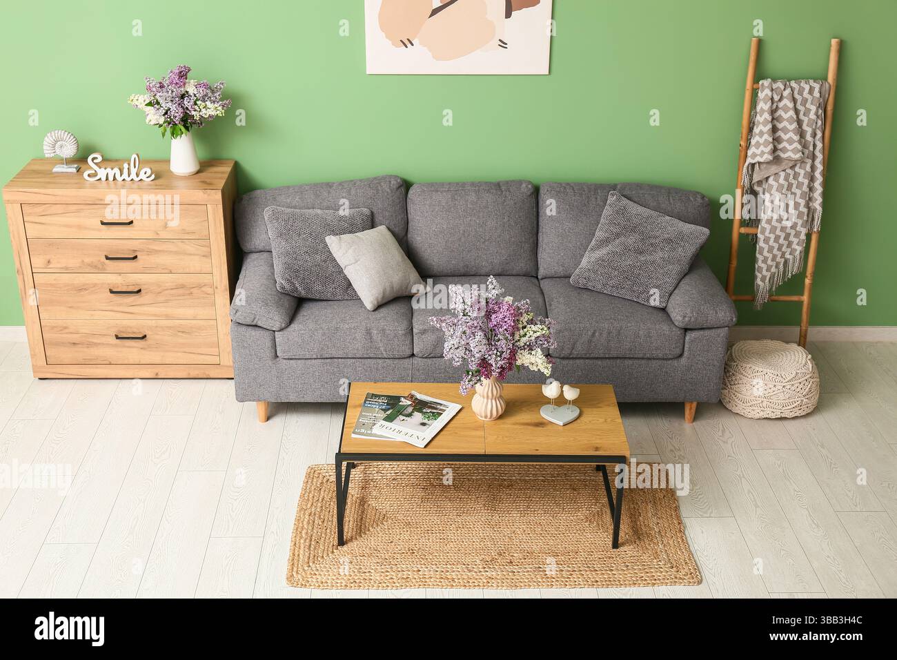 Interior of living room with sofa, table and lilac flowers in vases ...