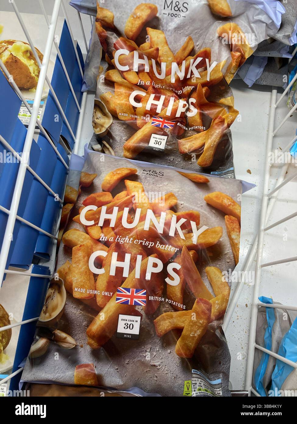 Marks and Spencer own brand bags of frozen Chunky Chips for sale in freezer cabinet, UK - Smartphone Captured Stock Image