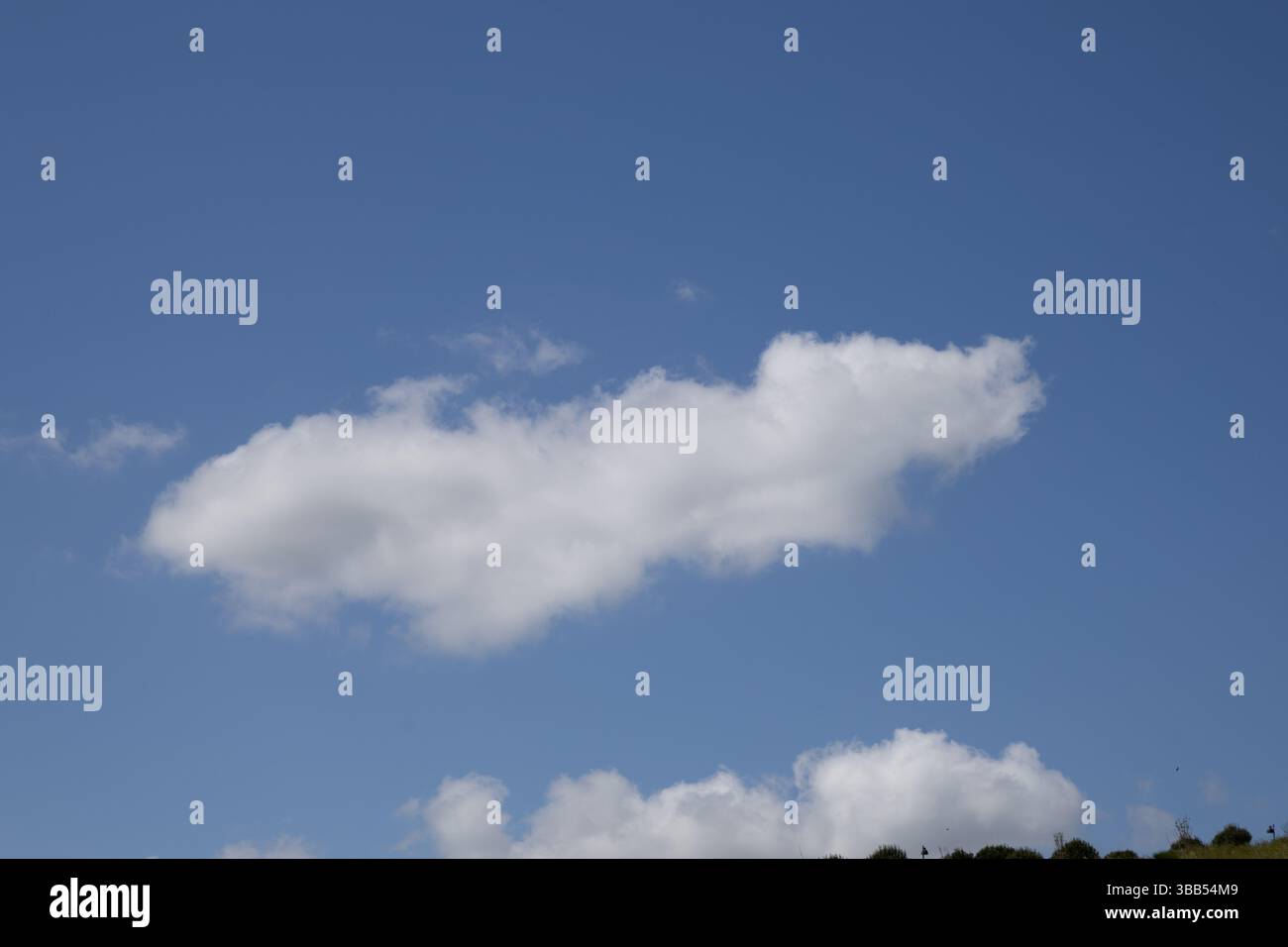 Single White Cloud Floating in a Bright Blue Sky Stock Photo