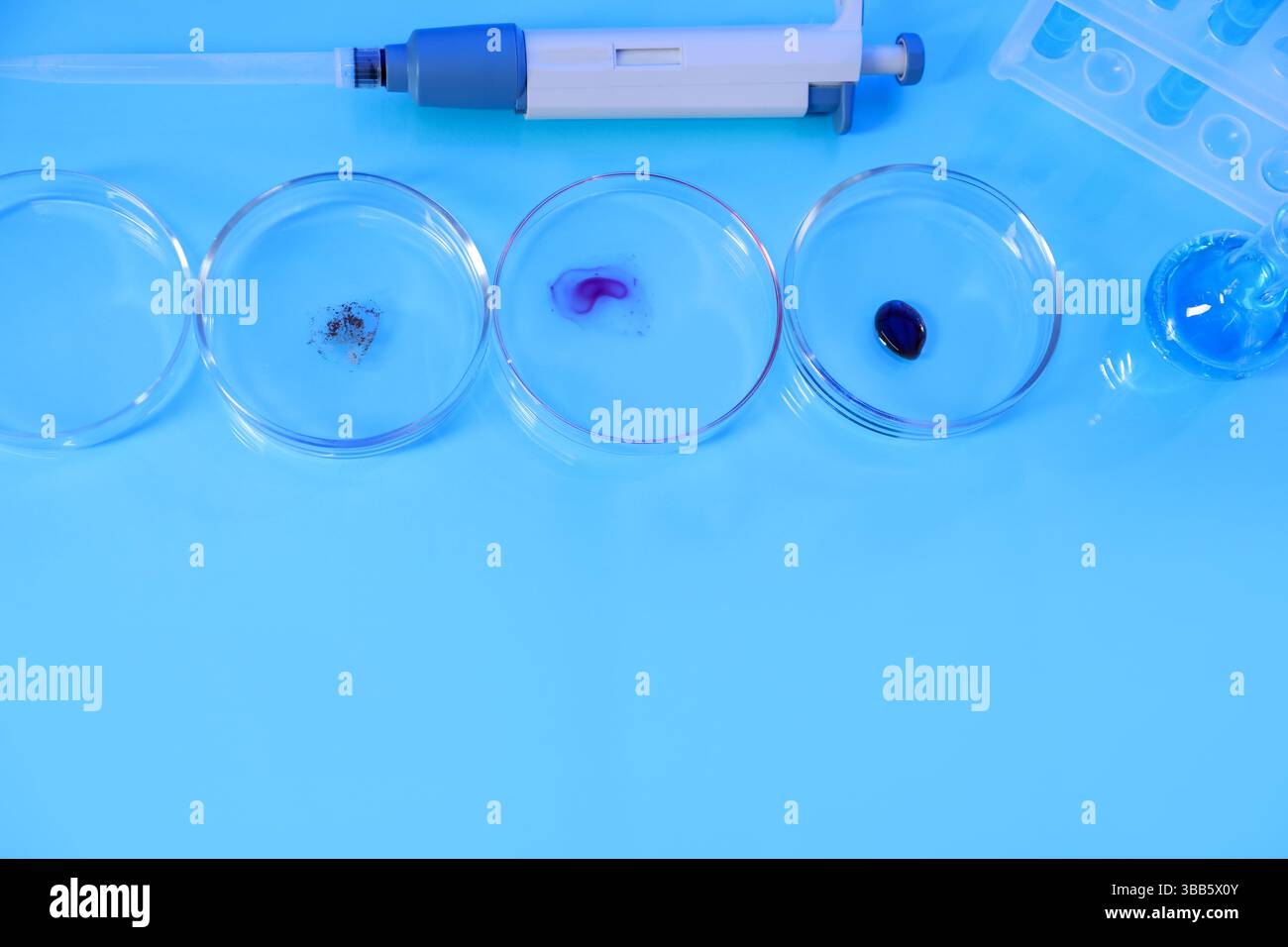 Petri dishes with samples, test tubes, micropipette and flask on light ...