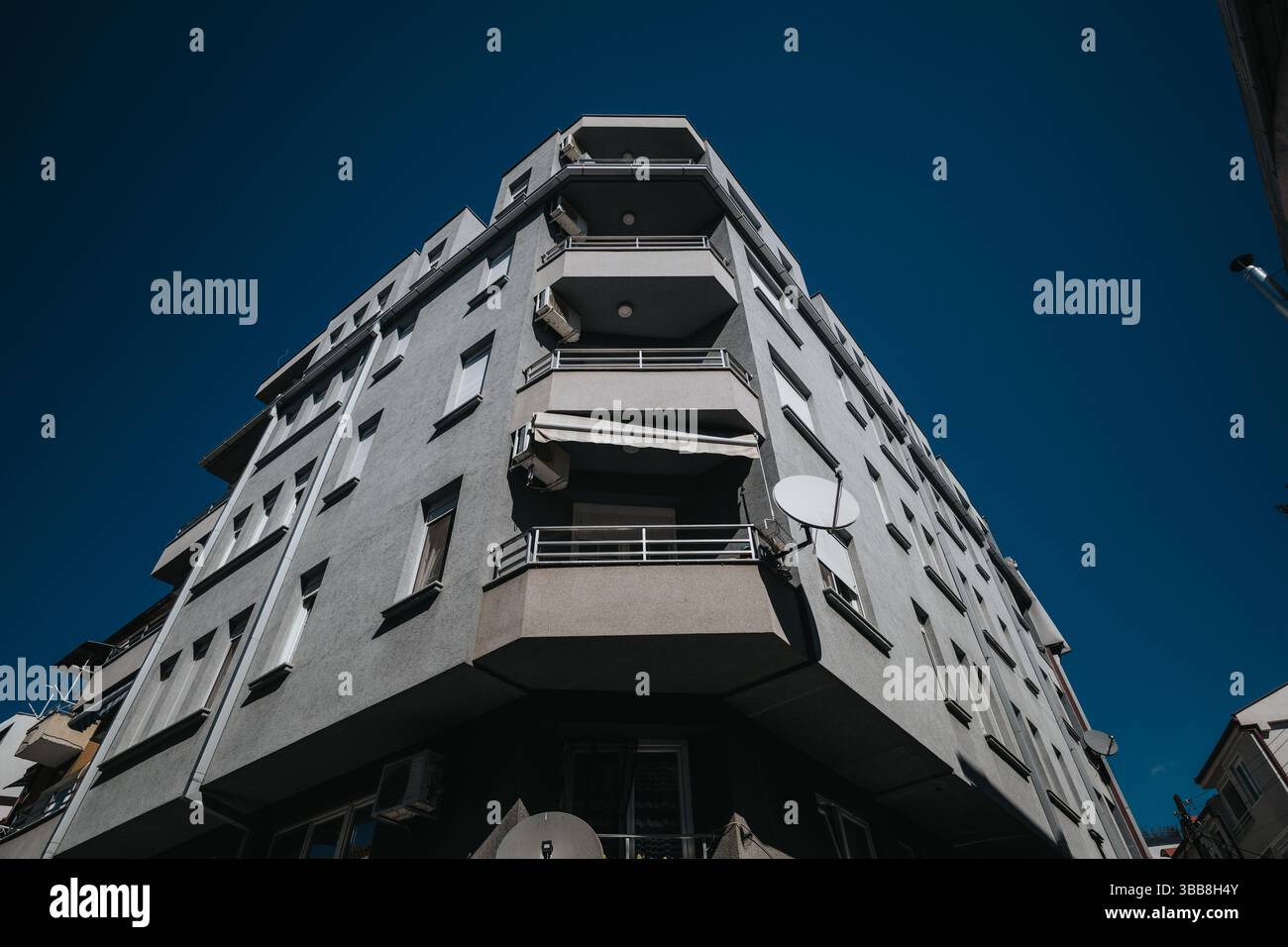 Modern multi-story apartment building against a clear blue sky Stock Photo
