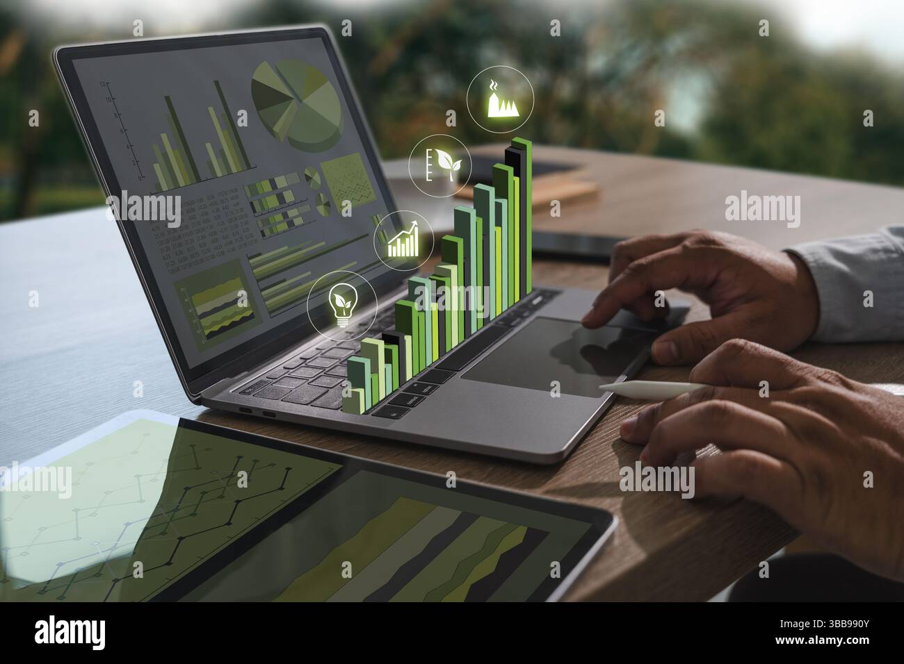 A sustainable business practices image shows person working laptop with digital graphs and charts, indicating data analysis and growth Stock Photo
