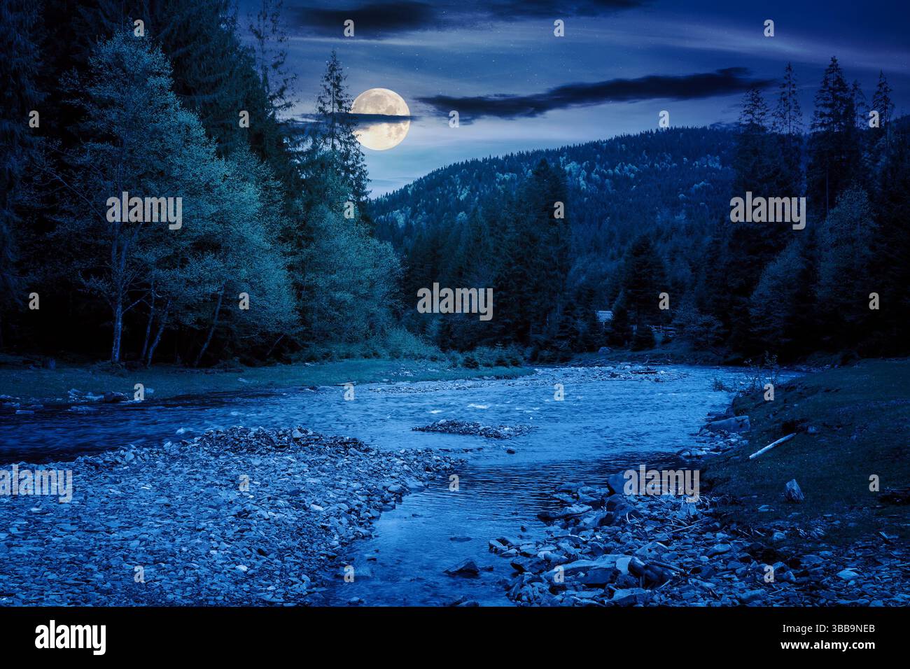 mountain landscape with river at night. mysterious scenery with stones in the water and forest on the shore in full moon light. starry sky with dark c Stock Photo