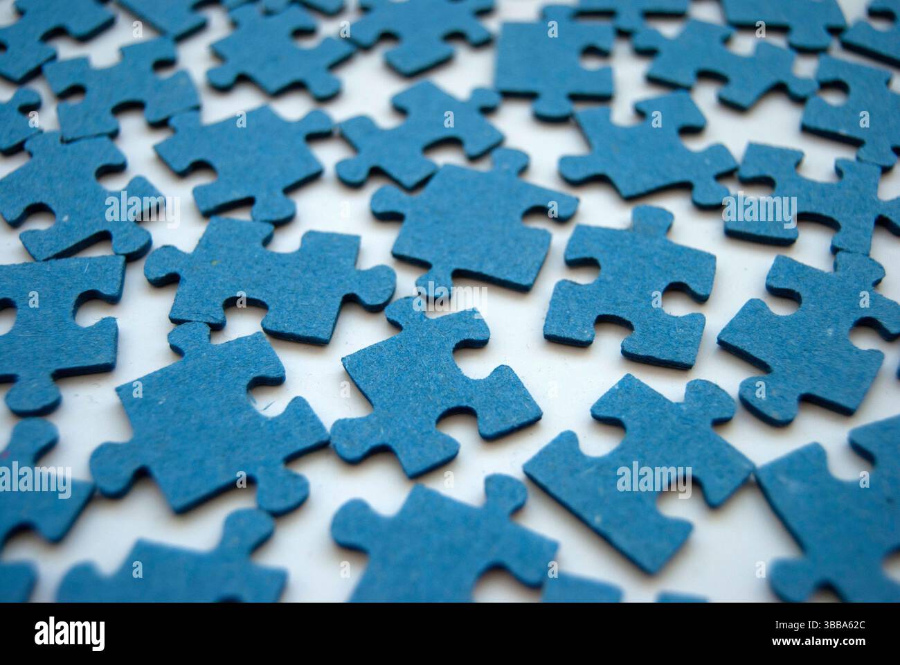 Blue jigsaw puzzle pieces close-up. Blue puzzles on white. Jigsaw puzzle background. Challenge and solution concept. Teamwork. Stock Photo