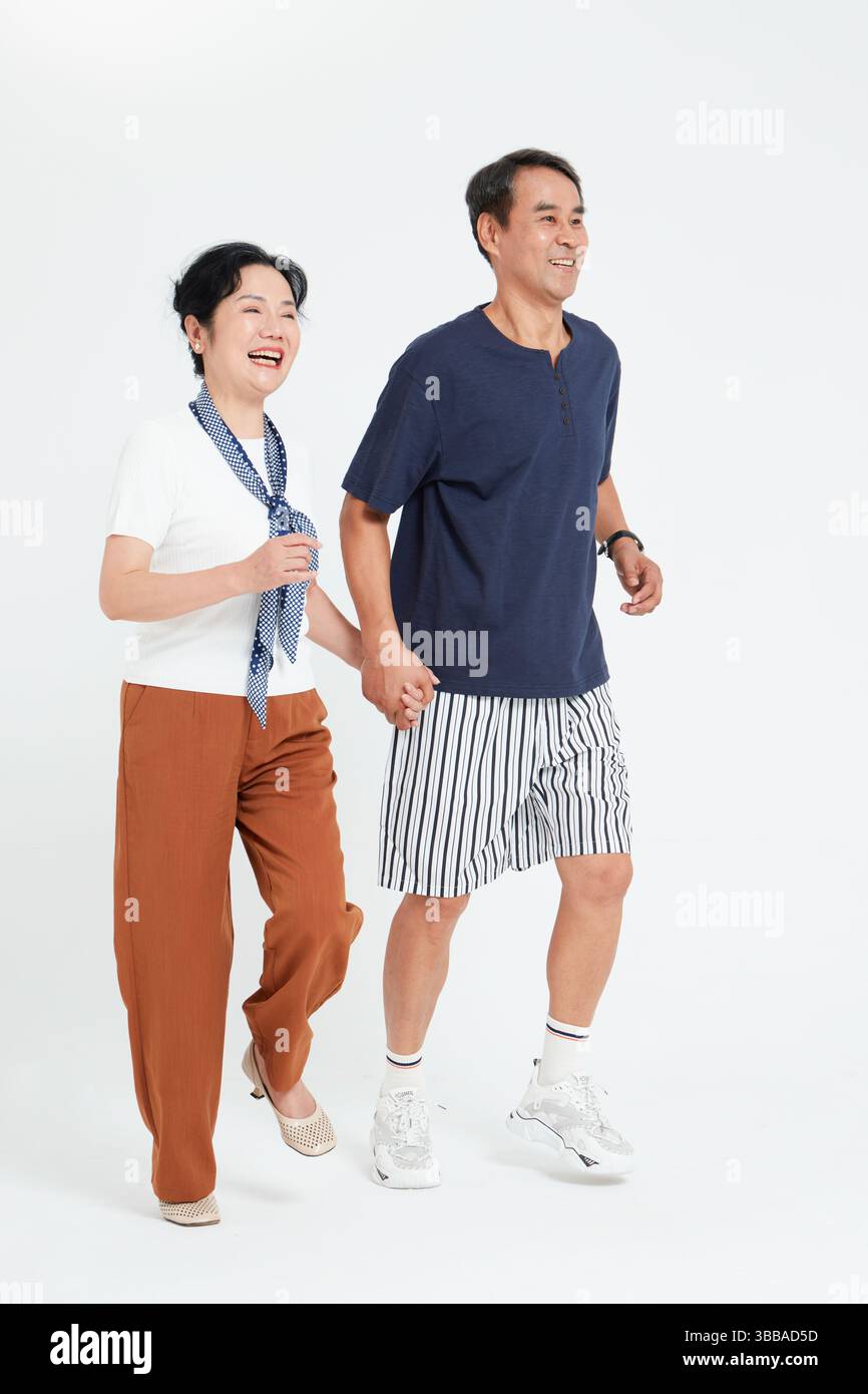 elderly couple running hand in hand​ Stock Photo