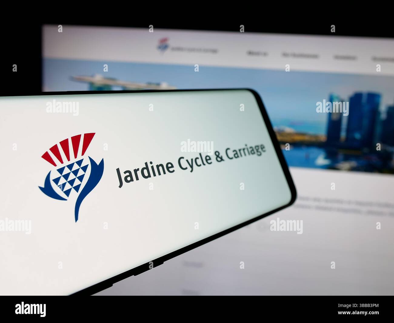 Stuttgart, Germany - 01-03-2024: Cellphone with logo of Singaporean company Jardine Cycle Carriage Limited on screen in front of website. Stock Photo