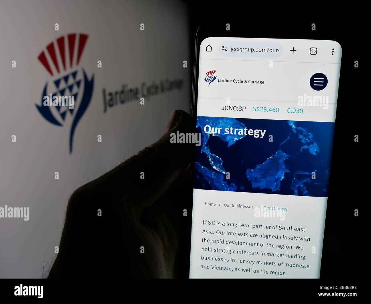 Stuttgart, Germany - 01-03-2024: Person holding mobile phone with website of Singaporean company Jardine Cycle Carriage Limited on screen with logo. Stock Photo