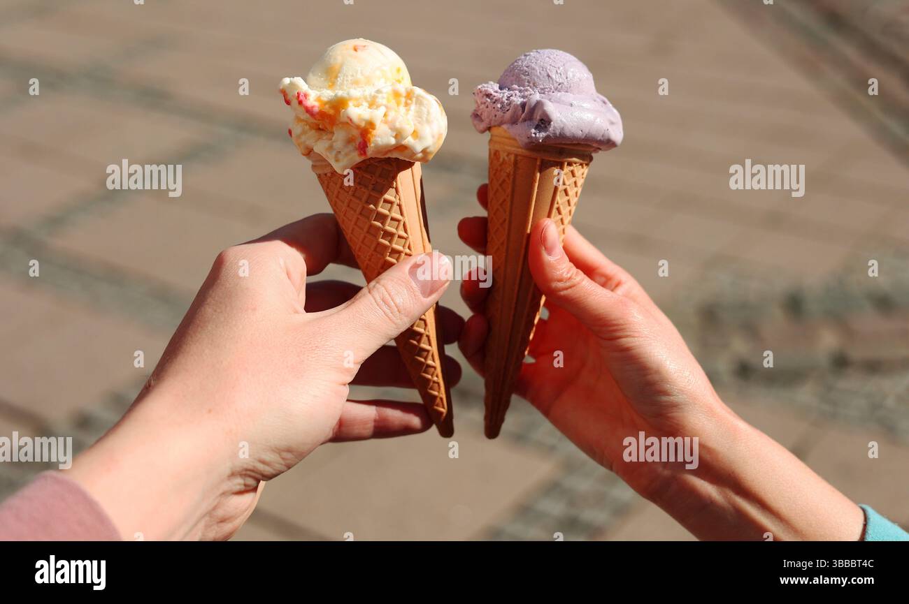 two hands holding two ice cream cones, date, couple in love Stock Photo