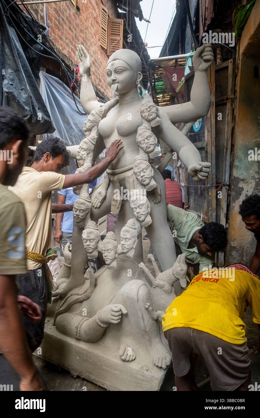 Craftsman transport a straw and clay statue of goddess Durga, Kumartuli district,  Durga Puja festival, Kolkata, Calcutta, India. Stock Photo
