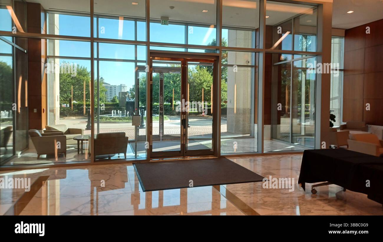 Charlotte, NC, USA – April 29, 2025: A modern building lobby looks out ...