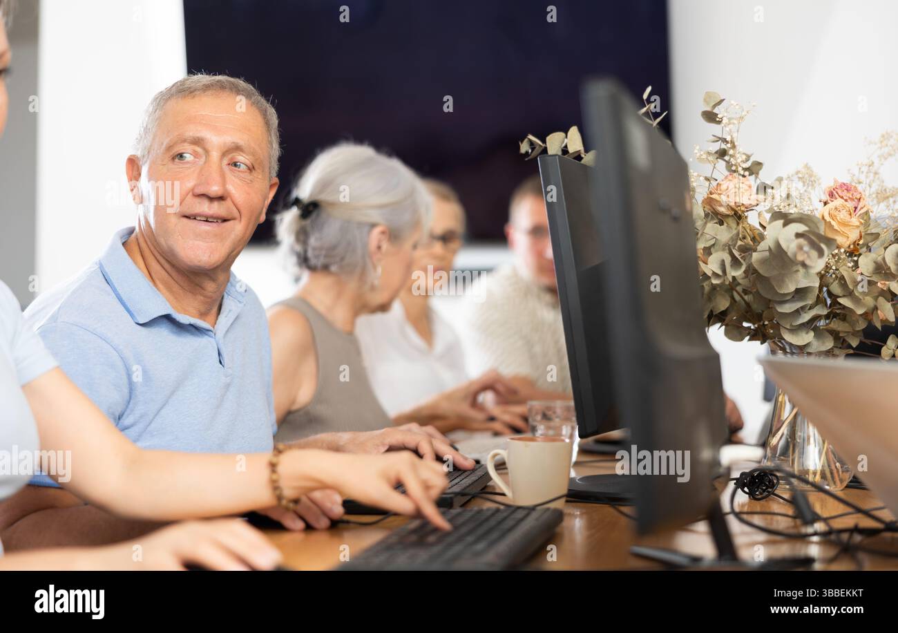 Old man learning computer programs in training room Stock Photo