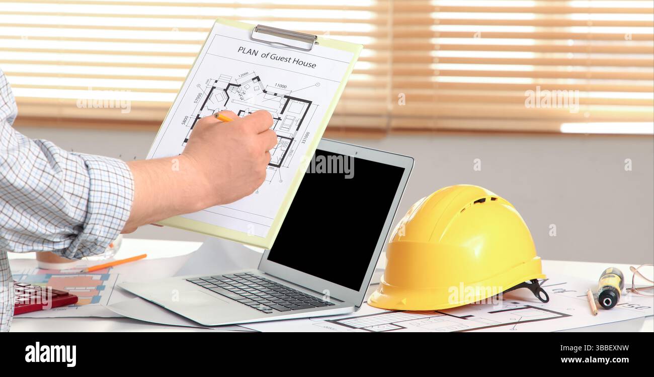Male constructor working with house plan in office Stock Photo