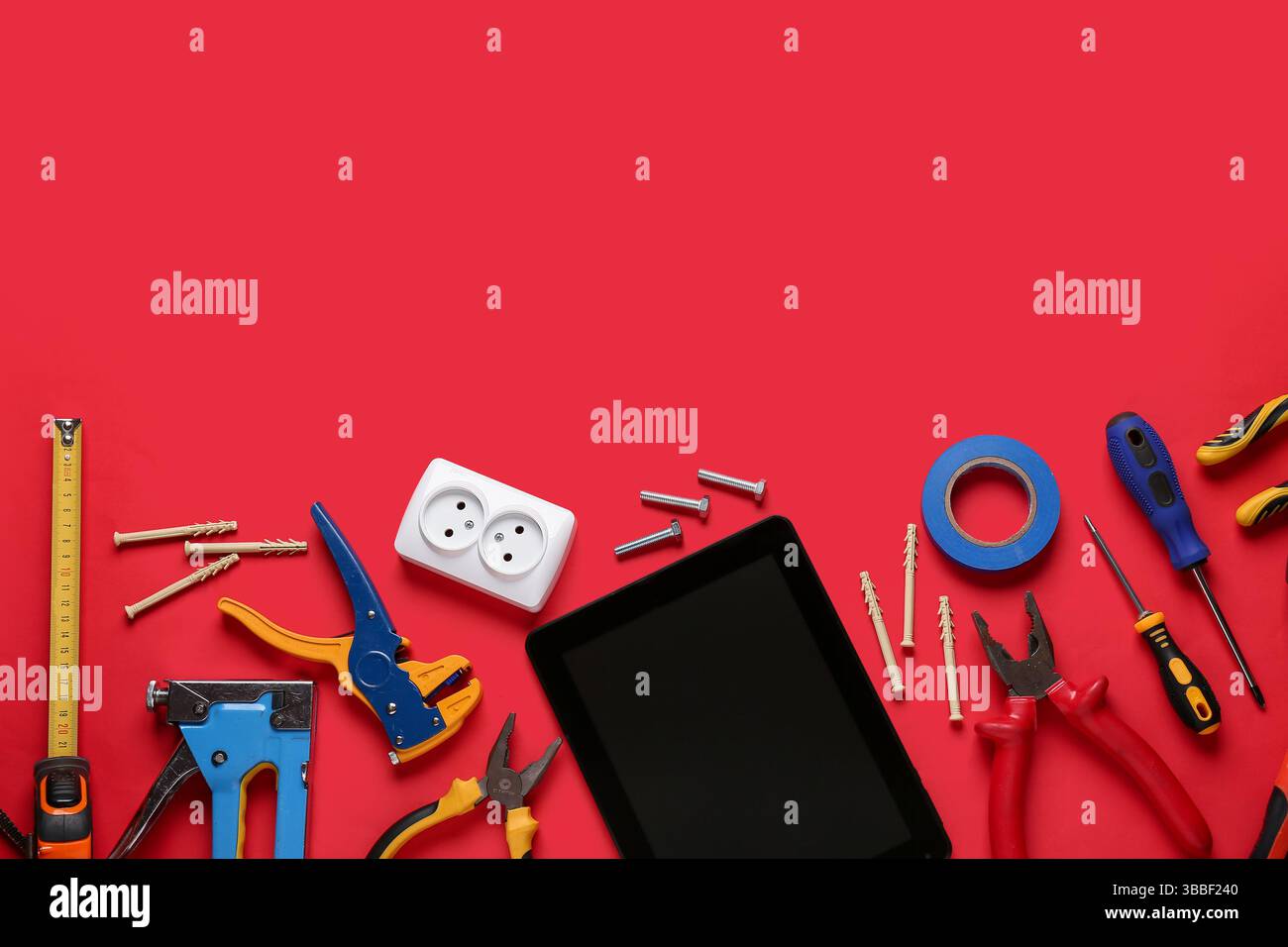 Tablet computer with blank screen and construction tools on red background Stock Photo