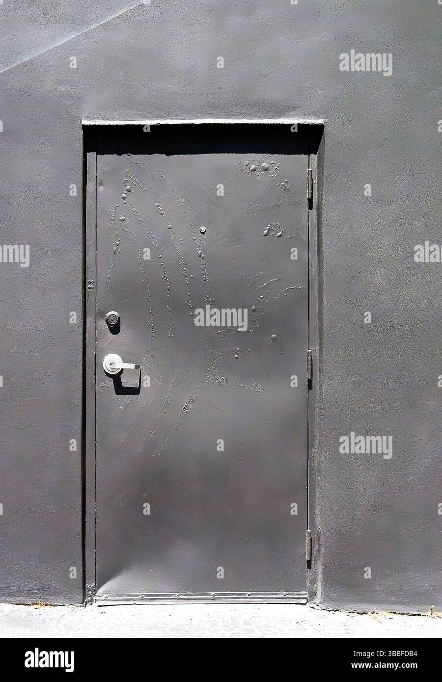 Grey door on grey wall Stock Photo