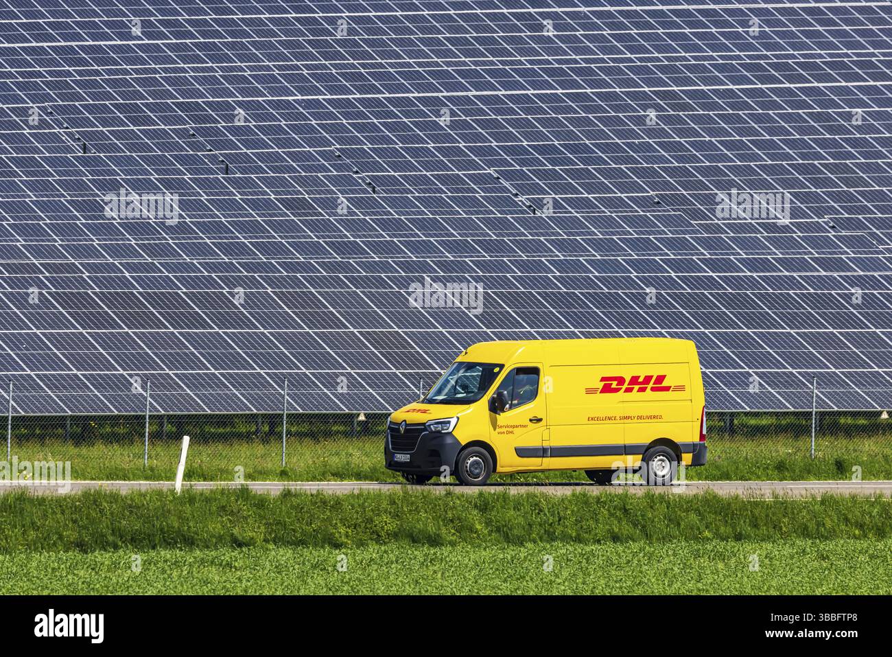 Agricultural land is used as a solar field. Vehicle from DHL. Nellingen in the Swabian Alb. Nellingen, Baden-Wuerttemberg, Germany, Europe Stock Photo