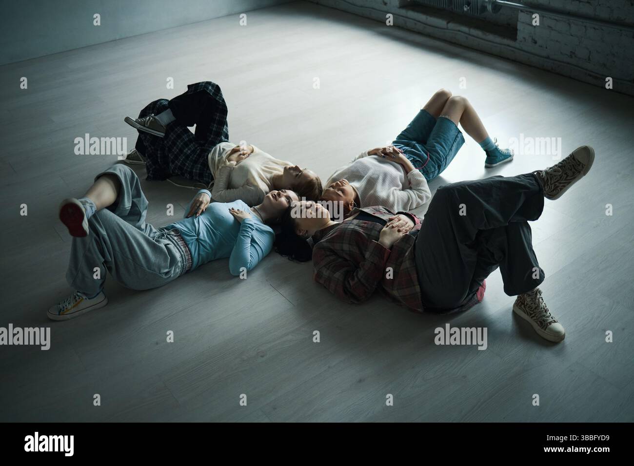 People Lying on Floor Relaxing in Modern Space Stock Photo