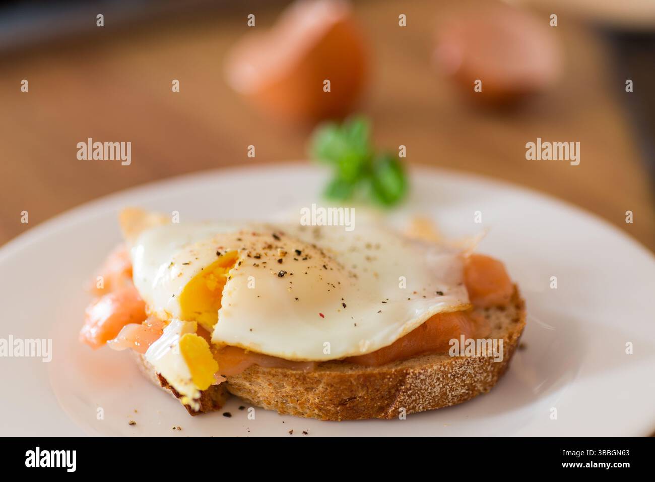 A slice of bread with a cooked egg and lightly salted red fish. Stock Photo