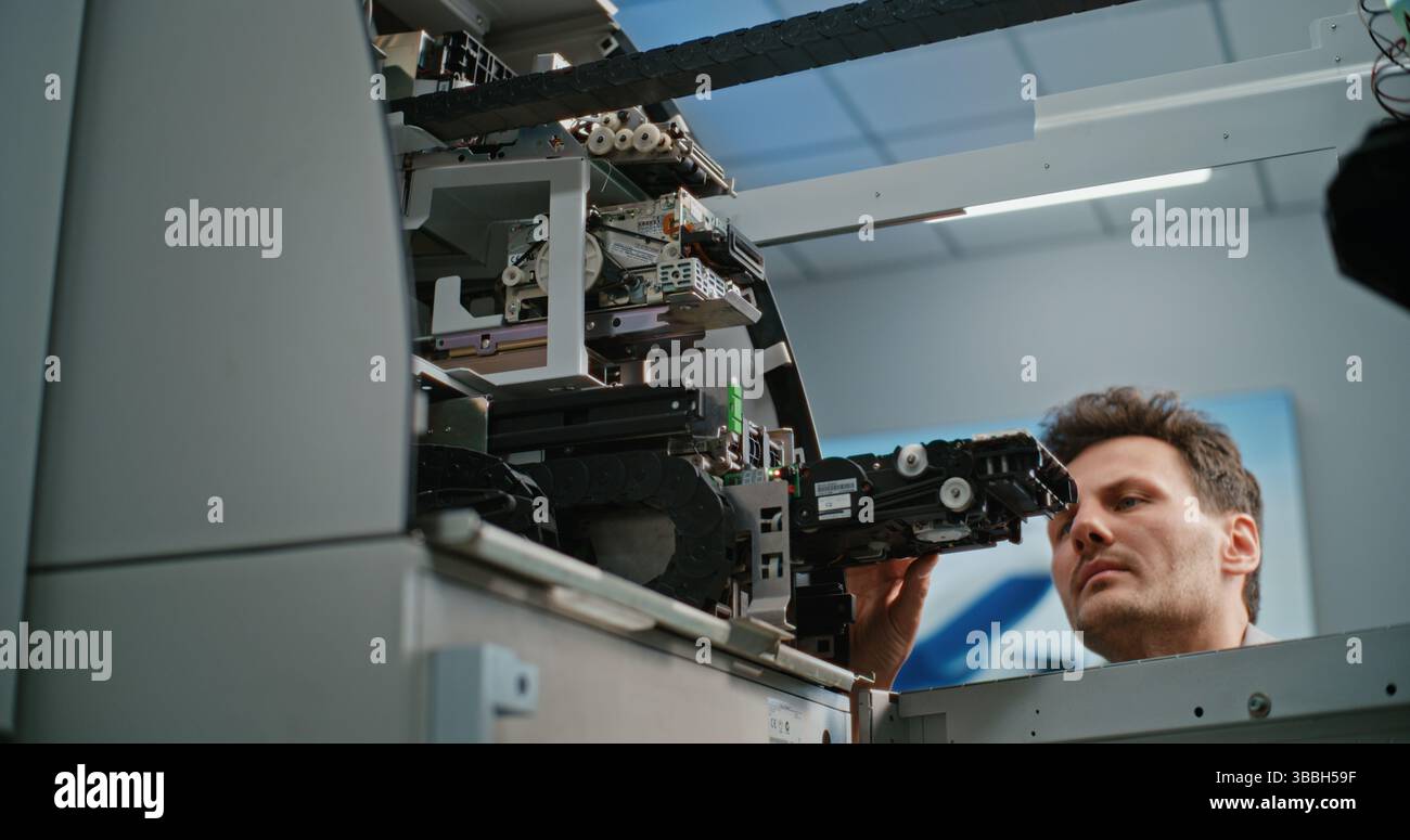Technician Servicing ATM Machine in Modern Airport Terminal. Male
