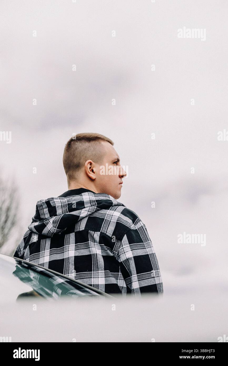 Young man thoughtful standing outdoors cloudy sky Stock Photo