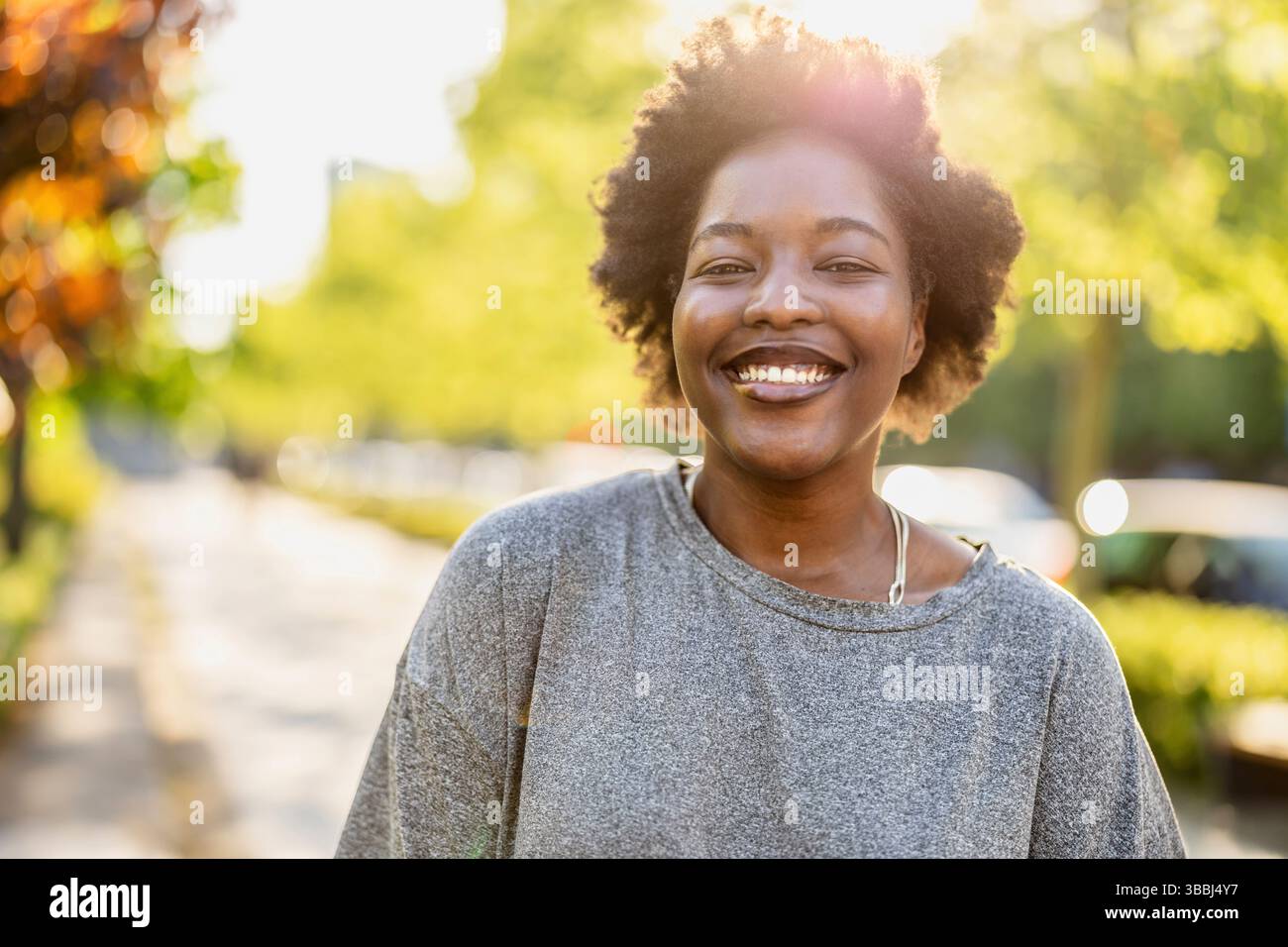 Smiling young woman in the park on a sunny day Stock Photo