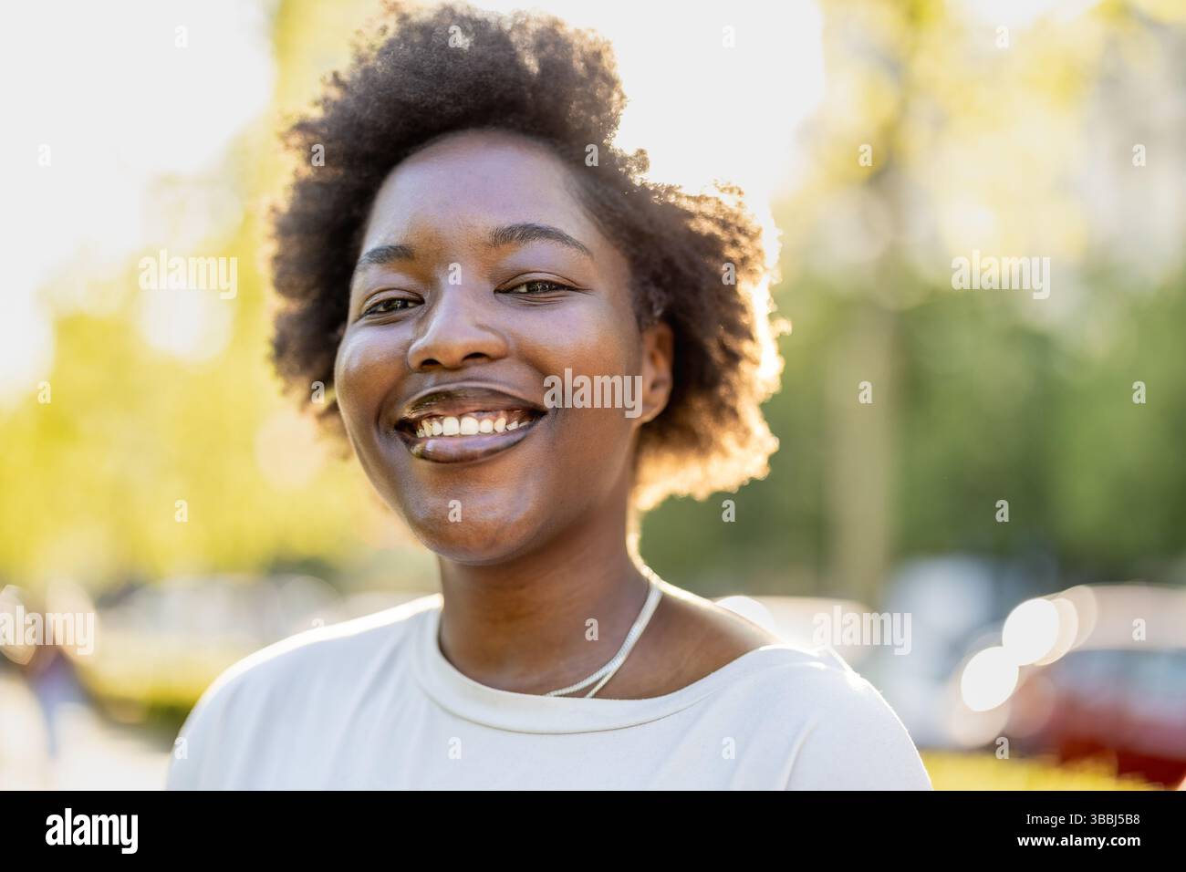 Smiling young woman in the park on a sunny day Stock Photo