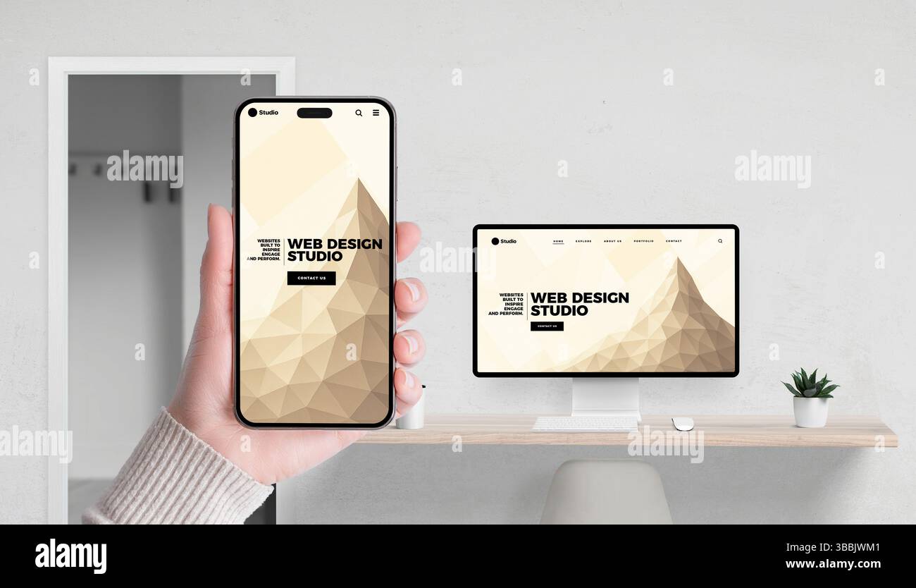 Web design studio concept with app and website shown on smartphone and computer in office setting Stock Photo