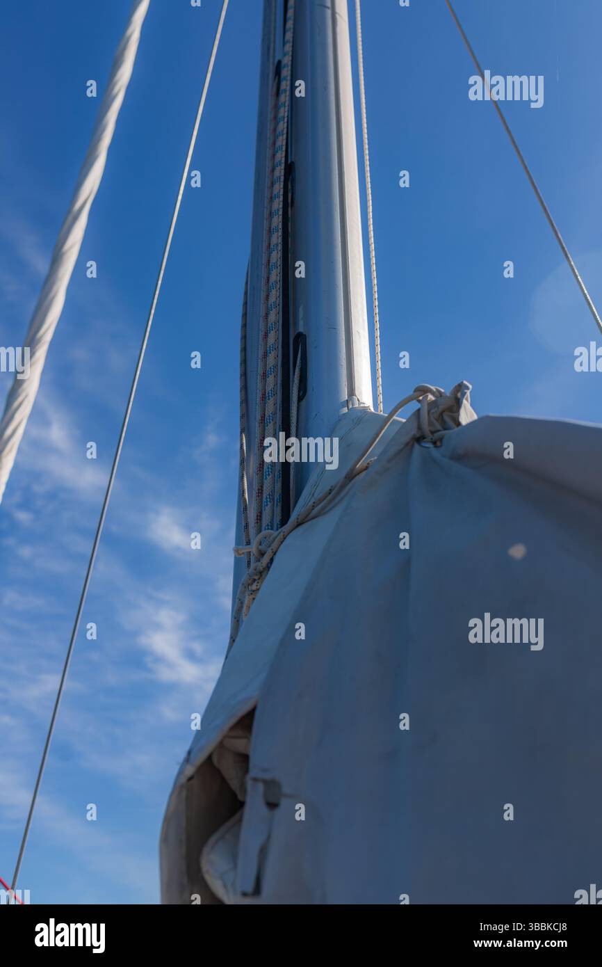 Vertical view of yacht mast with ropes and rigging extending upwards ...