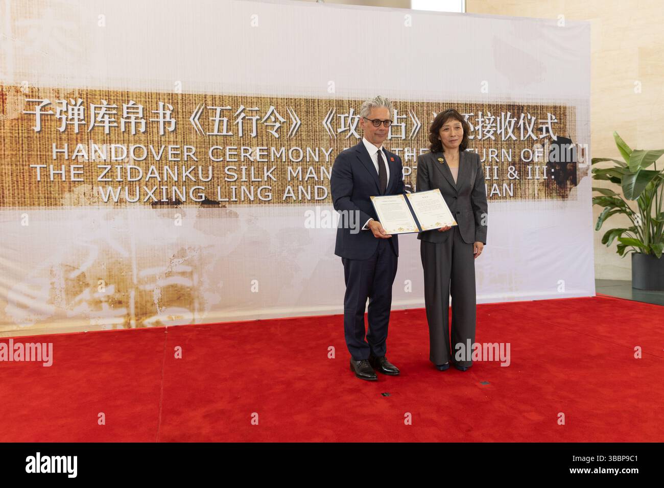 (250516) -- WASHINGTON, May 16, 2025 (Xinhua) -- Chase F. Robinson (L), director of the Smithsonian's National Museum of Asian Art, receives a certificate of appreciation from Zhu Ye, deputy director-general of Office for the Recovery and Restitution of Lost Cultural Property, National Cultural Heritage Administration of China, during a handover ceremony of the ancient Zidanku Silk Manuscripts from the Warring States period at the Chinese Embassy in the United States in Washington, D.C., on May 16, 2025. The Smithsonian's National Museum of Asian Art on Friday officially returned the Zidanku S Stock Photo
