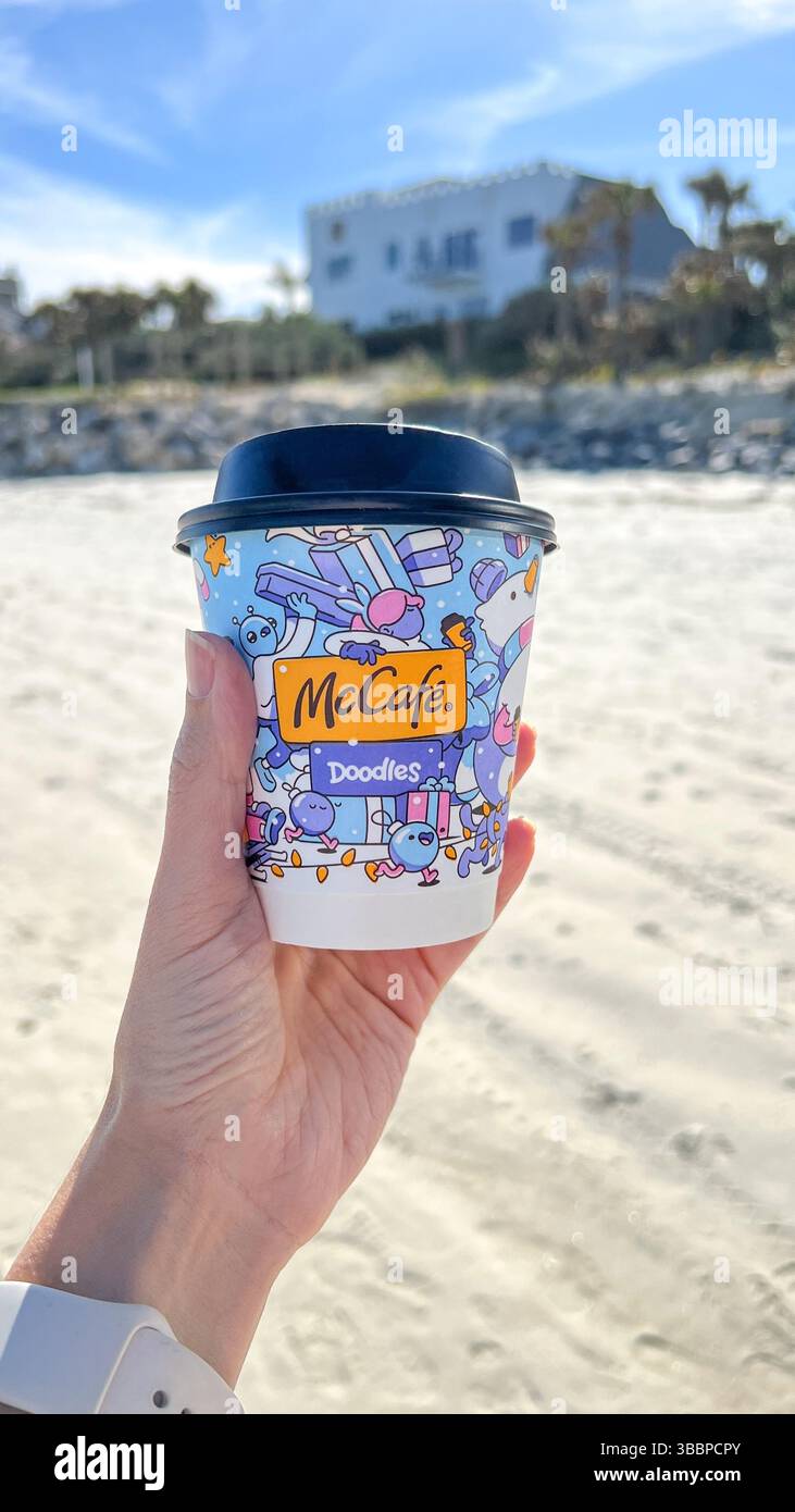 Person holding a cup of McCafe coffee from McDonalds fast food restaurant  against leaves, foliage background for spring and autumn Stock Photo - Alamy