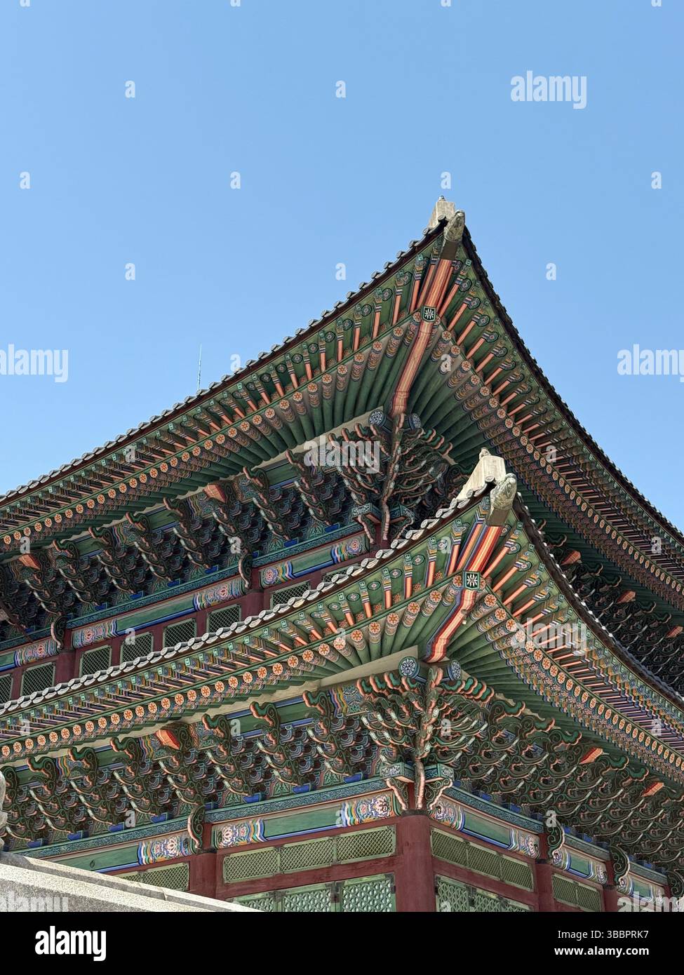 Colorful dancheong patterns decorate the roof of a traditional Korean palace, a striking display of symmetry and cultural craftsmanship. - Smartphone Captured Stock Image
