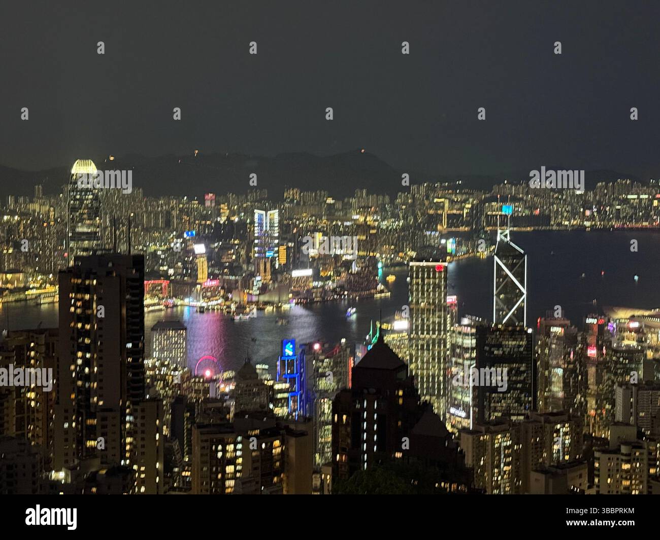 The vibrant skyline of Hong Kong lights up Victoria Harbour at night, showcasing the city’s energy, architecture, and global stature. - Smartphone Captured Stock Image