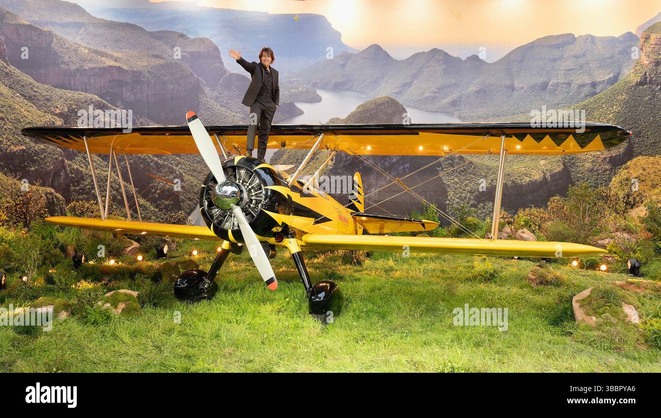 Actor Tom Cruise waves from a car on his way to the premiere