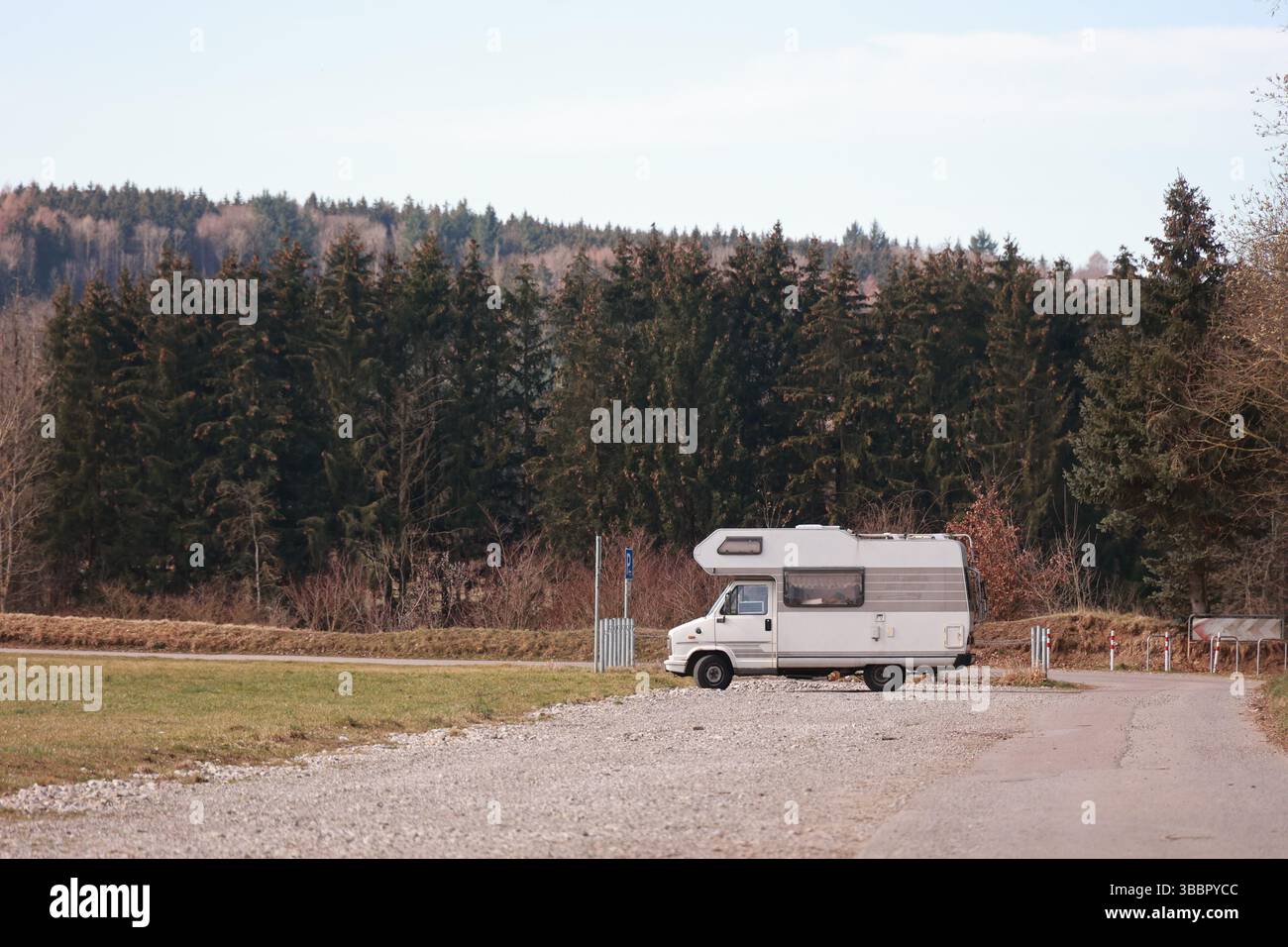 White camper van is parked on a gravel road in a forest Stock Photo - Alamy