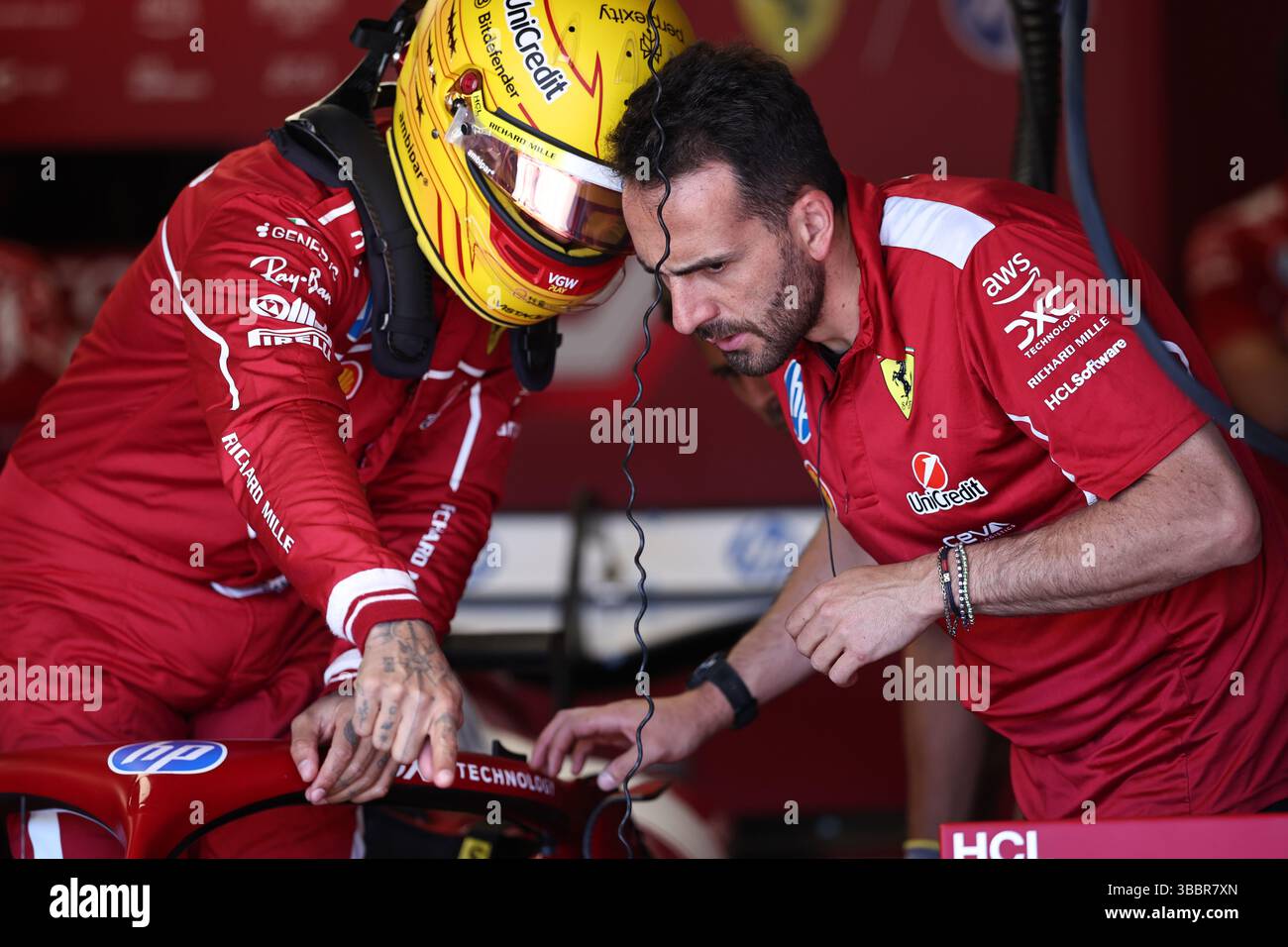 Imola. 16th May, 2025. Ferrari's driver Lewis Hamilton (L) of Britain prepares before the second practice session at the Autodromo Internazionale Enzo e Dino Ferrari race track in Imola, Italy, May 16, 2025, ahead of the Formula One Emilia Romagna Grand Prix. Credit: Li Jing/Xinhua/Alamy Live News Stock Photo