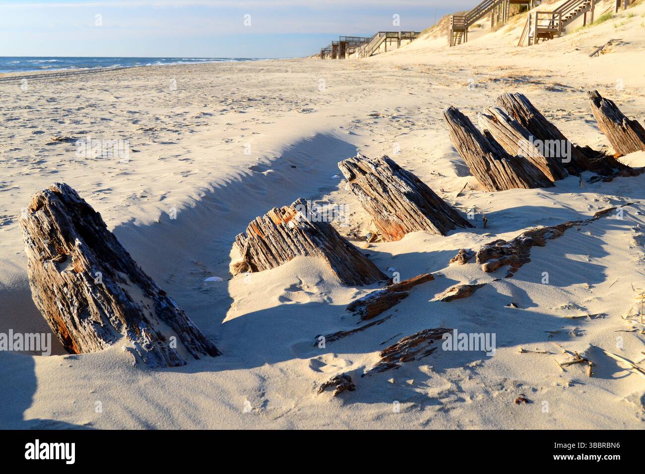 The remains of a shipwreck poke through the sands along the Outer Banks of North Carolina Stock Photo