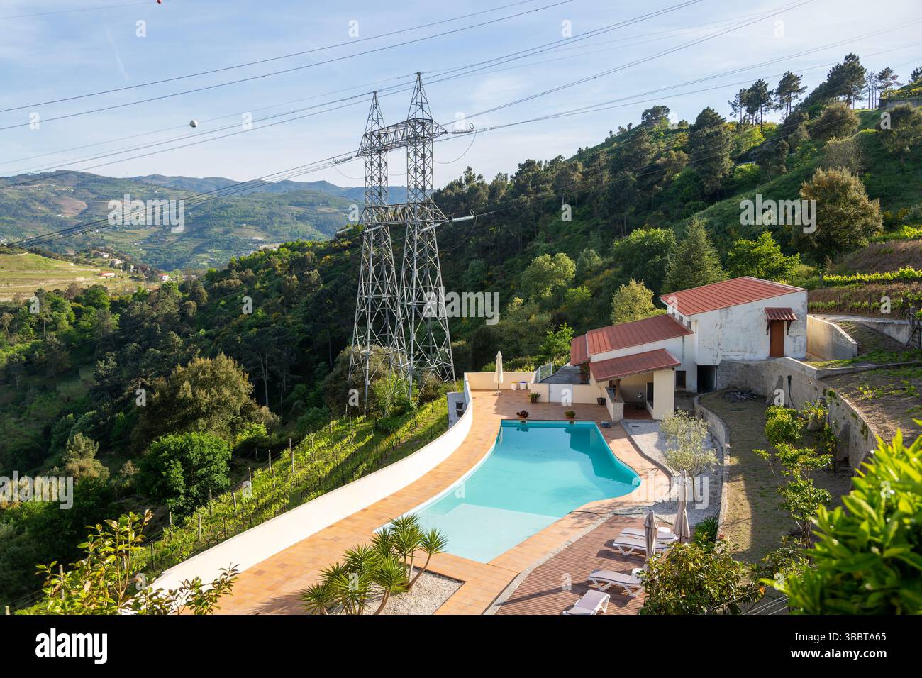 Electricity pylons crossing countryside over swimming pool, Tresouras ...