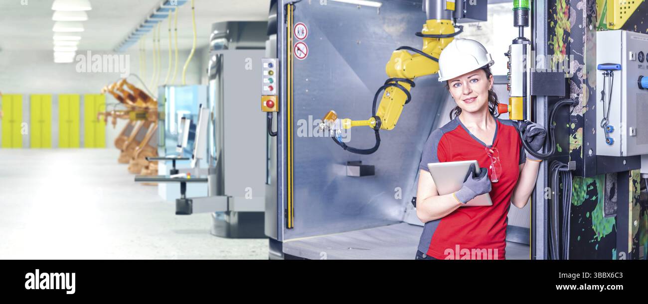 A young female technician while machine constructing in a manufacturing plant Stock Photo